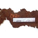 A piece of rusty metal is embedded with a photograph of the Branford beach where it was found in this work by Lilliannna Maria Baczeski.