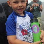 William Aspinwall shows the "Protect Our Wildlife: Break the Single-Use Plastic Habit" sticker on his water bottle after he and his family picked up trash at Bluff Point State Park on Aug. 1.