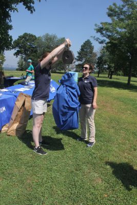 Ireland Wilson, left, senior conservation manager for the Mystic Aquarium, lifts a scale with a bag of trash attached as MaryEllen Mateleska, director of education and conservation at the aquarium, reads the scale.