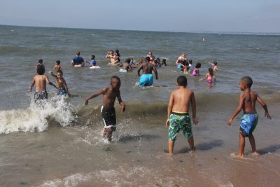 Summer campers from the New Britain YWCA frolic in the surf at Lighthouse Point Park.