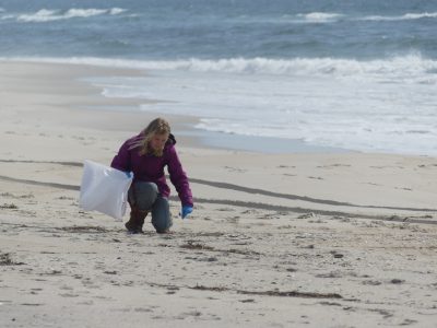 A participant in balloon debris survey collects trash at Jones Beach.