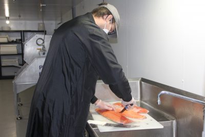 Matt Leegwater, facility manager for Ideal Fish, filets a salmon for one of the company's online orders.