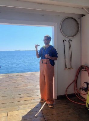 Zachary Gordon checks an oyster on the Deluxbury Oyster Co. float in Duxbury Bay, MA, where he worked until accepting the CT Sea Grant position.