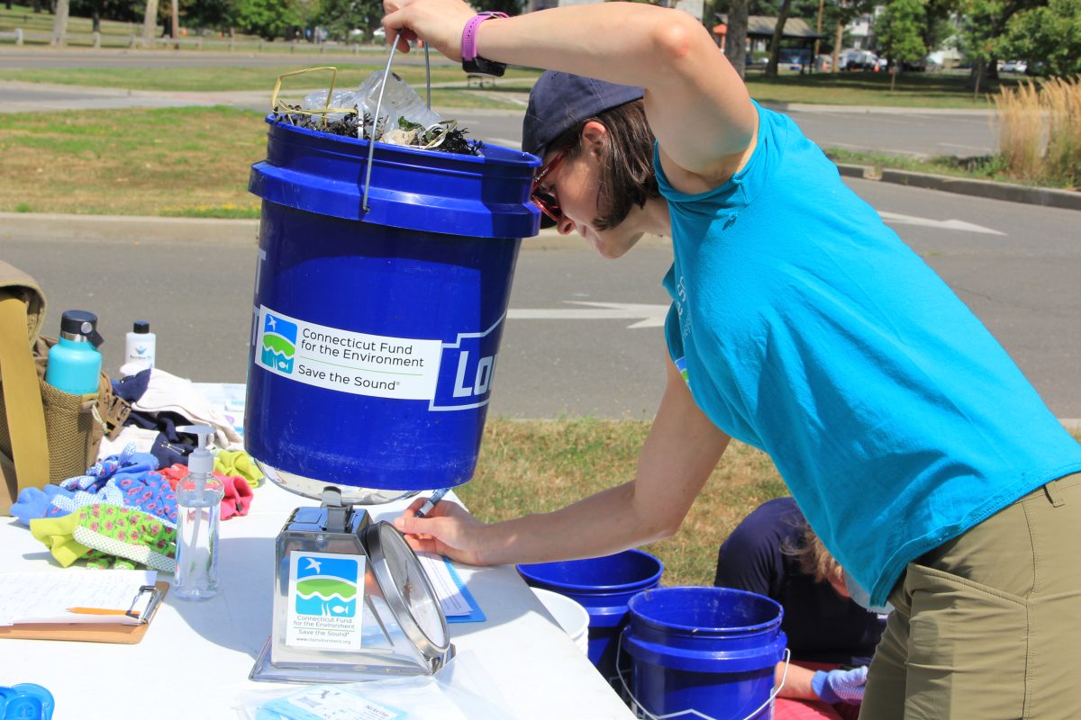 Annalisa Paltauf of Save the Sound weighs a bucket of trash collected at Seaside Park on Aug. 15.