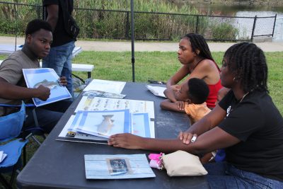 CPEN employee Jaylin Ambrose-Cooper teaches participants about the different types of fish that can be caught in the Pequonnock River.