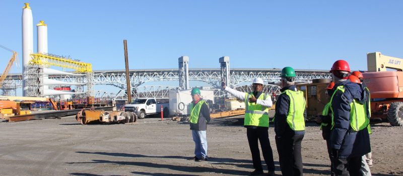 Ulysses Hammond, interim executive director of CT Port Authority, points to components of the South Fork wind farm being stage at State Pier in New London during a Nov. 20 tour of the site for about 15 people, including CTSG Director Sylvain De Guise, third from left, and other CTSG staff members.
